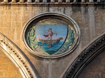 Ma quello stemma biancorosso continu� a essere utilizzato nei secoli successivi, cominciando una lunga convivenza con il precedente e pi� antico eblema cittadino: il �Barione� (qui quello presente sulla facciata di Palazzo Fizzarotti). Quest�ultimo raffigurava un cherubino in piedi su una barca nell'atto di scoccare una freccia, circondato dal mare e accompagnato da un delfino